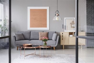 flowers on cooper table with grey sofa in a front rooom